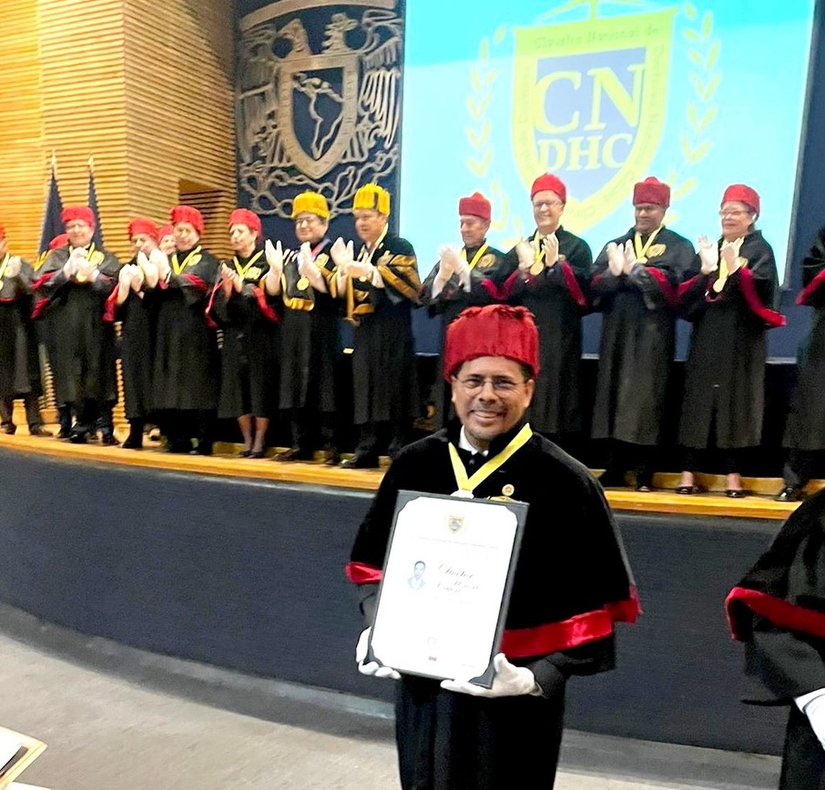 Mario Enrique Herrera Carrasco sostiene su diploma de Doctor Honoris Causa ante el Claustro Nacional de Doctores Honoris Causa, Ciudad de México