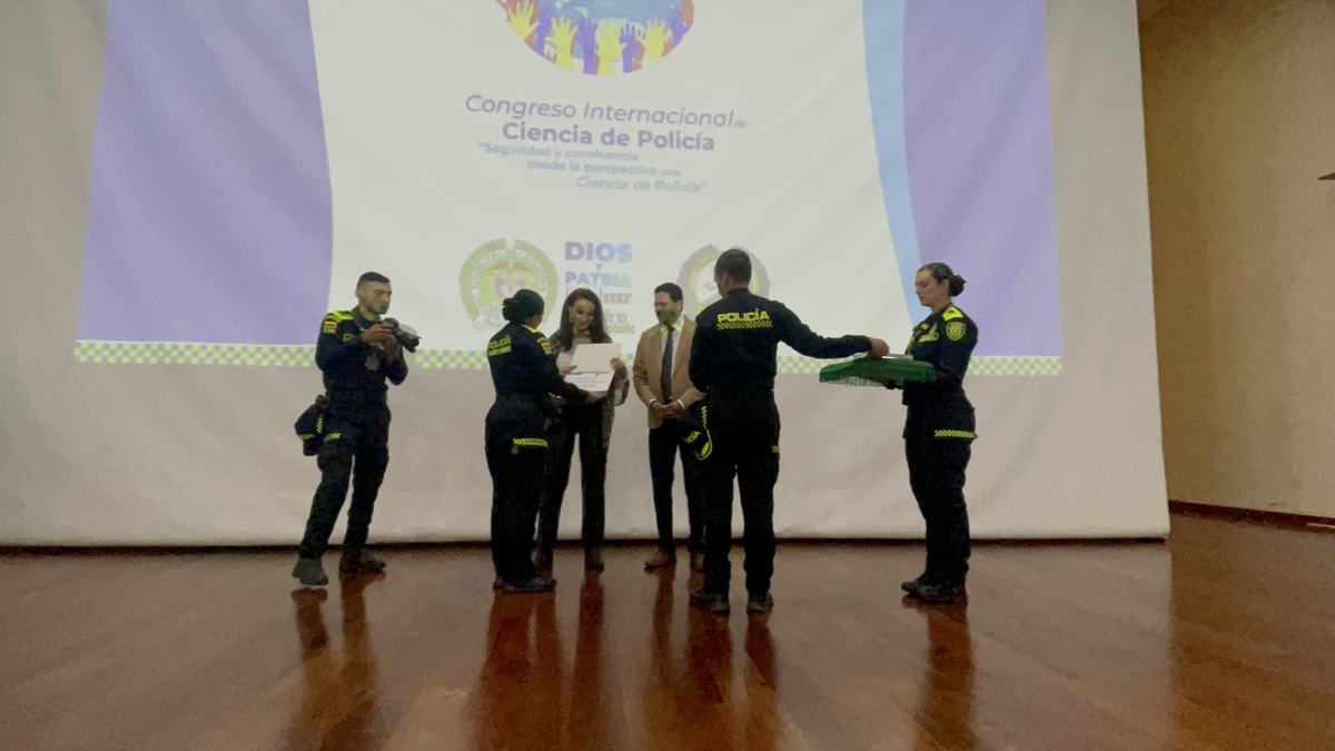 Mario Enrique Herrera Carrasco recibe un reconocimiento de oficiales de la Policía Nacional de Colombia tras su ponencia en Bogotá, 2022